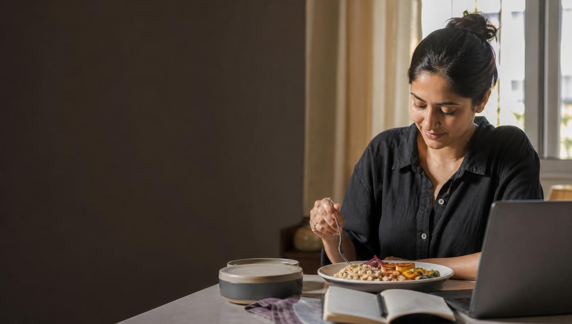 Working professional enjoying a healthy vegetarian meal in a home office